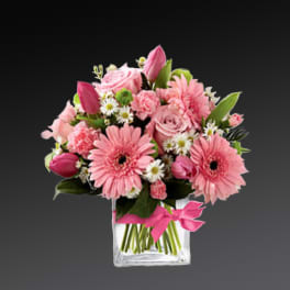 Pink mixed bouquet in a clear square vase