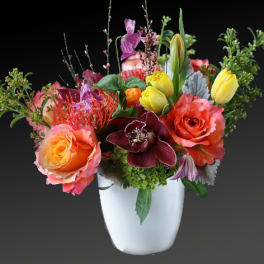 Colorful mixed flower arrangement in a white vase