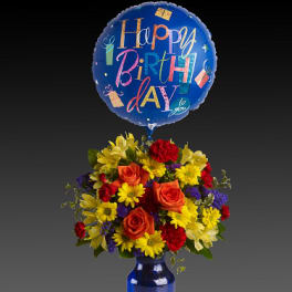 Birthday balloon above a colorful flower arrangement in a blue vase