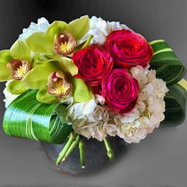 Bouquet of red roses, green orchids, and white hydrangeas in a vase