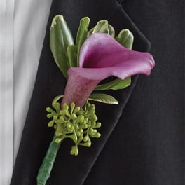 Purple calla lily boutonniere with green accents on a black jacket