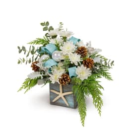 White flowers in a square vase with pinecones and a starfish accent