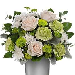 Bouquet of pale roses, white daisies, and green carnations in a glass vase