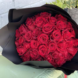 Bouquet of red roses wrapped in black paper