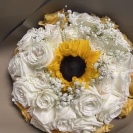 Bouquet of white roses with a yellow sunflower center