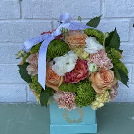 Mixed bouquet of roses and green chrysanthemums in a blue box with ribbon