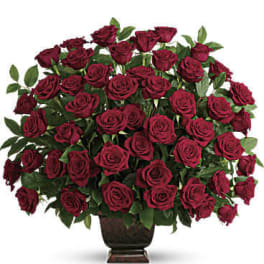 Large bouquet of deep red roses in a dark vase