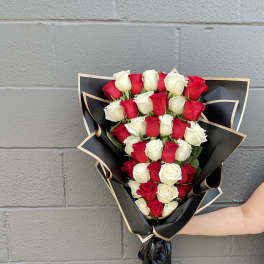 Bouquet of red and white roses wrapped in black paper