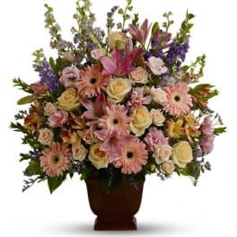 Mixed pink and cream flowers in a brown urn vase