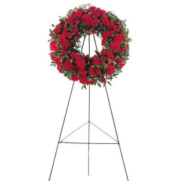 Red floral wreath on a metal easel stand
