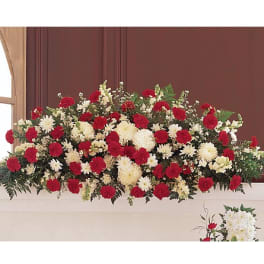 Red and white floral casket spray with carnations and daisies