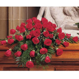 Casket spray of red roses on a wooden casket