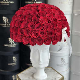 Large dome of red roses in a white sculpted vase