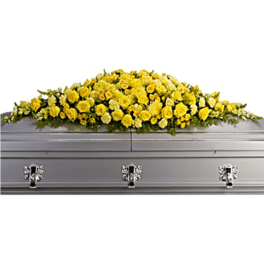 Yellow floral casket spray on a gray casket