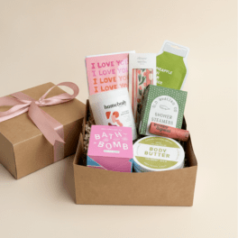 Gift box with bath and body products and a pink ribbon-tied box