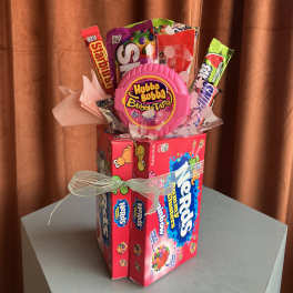 Candy gift arrangement with gum packs and a pink bubble gum container