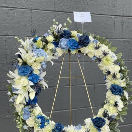 Blue and white floral wreath on a gold stand