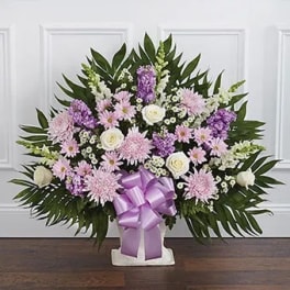 Lavender and white floral standing spray with a purple ribbon bow