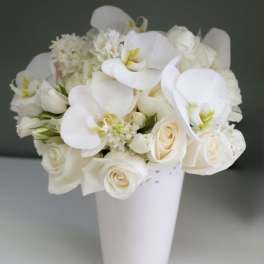 White floral bouquet in a tall white vase