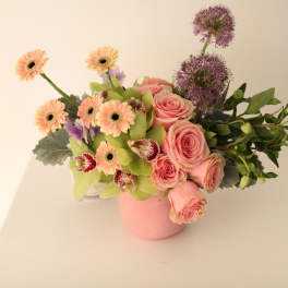 Pink roses and peach gerbera daisies in a pink vase