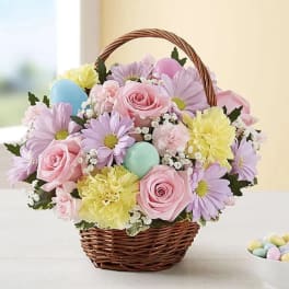 Basket of pastel flowers with decorative eggs