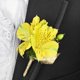 Yellow boutonniere with a small bud pinned to a black suit jacket