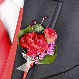 Red and pink boutonniere pinned to a dark suit jacket