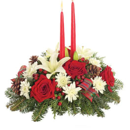 Holiday centerpiece with red roses, white lilies, and two red candles