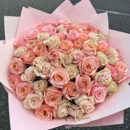 Large bouquet of pale pink and peach roses wrapped in pink paper
