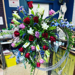Standing floral spray with red, pink, white, and blue flowers