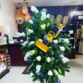 Standing floral spray with white and blue flowers on an easel