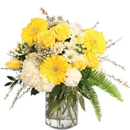 Yellow and white flowers arranged in a clear glass vase