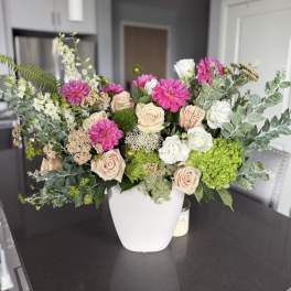 Mixed bouquet of pink and white flowers in a white vase