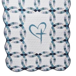 Quilted white blanket with blue ring pattern and a heart motif