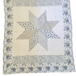 Patchwork quilt with a large star pattern and floral border