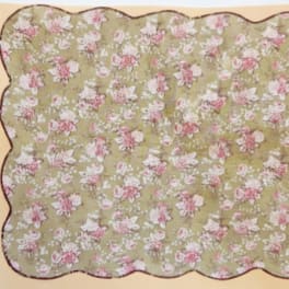 Floral-patterned scalloped fabric in pink and white on a green background