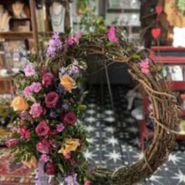 Floral wreath with pink, purple, and orange flowers on a twig ring