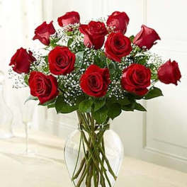 Red roses arranged in a clear glass vase