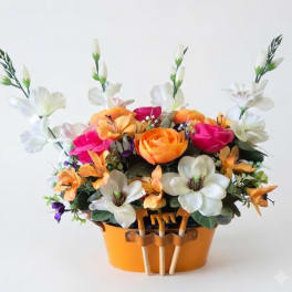 Colorful flower arrangement in an orange container with small gardening tools