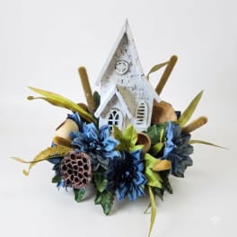 Blue floral arrangement with a white decorative church centerpiece