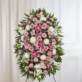 Standing funeral spray with pink roses, white lilies, and chrysanthemums