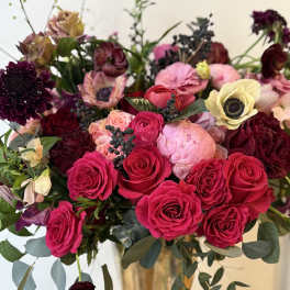 Bouquet of hot pink and burgundy roses in a gold vase