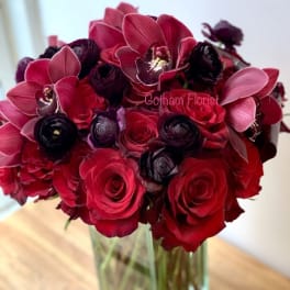 Red and burgundy bouquet in a clear glass vase