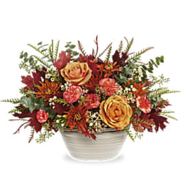 Autumn floral arrangement in a white ceramic bowl with orange and pink blooms