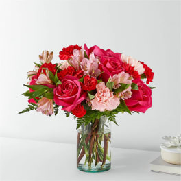 Bouquet of pink roses, carnations, and alstroemeria in a glass vase