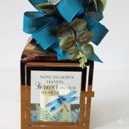 Memorial lantern with a blue ribbon bow and a candle inside