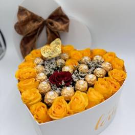 Heart-shaped box of yellow roses with chocolates and a red rose