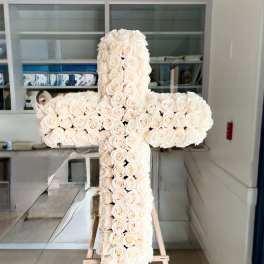Large white rose cross on a wooden easel