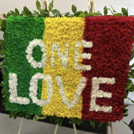 Floral display spelling ONE LOVE in green, yellow, red, and white