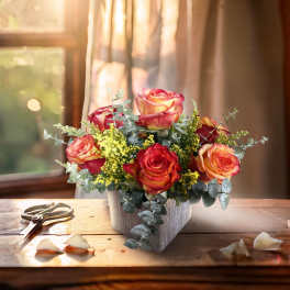 Arrangement of red and yellow roses in a gray container